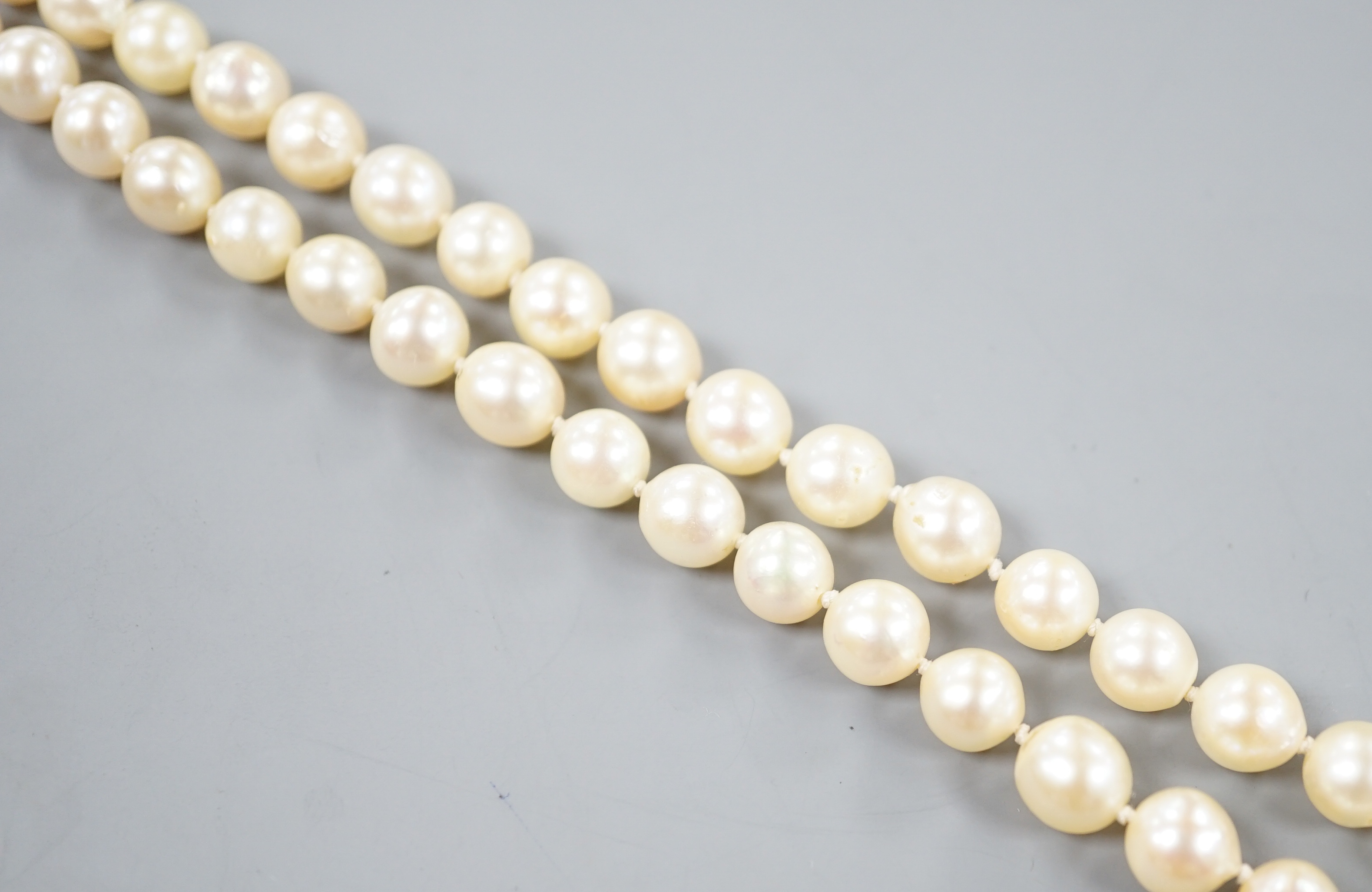 A single strand cultured pearl necklace, with yellow metal and moonstone set clasp, 56cm.